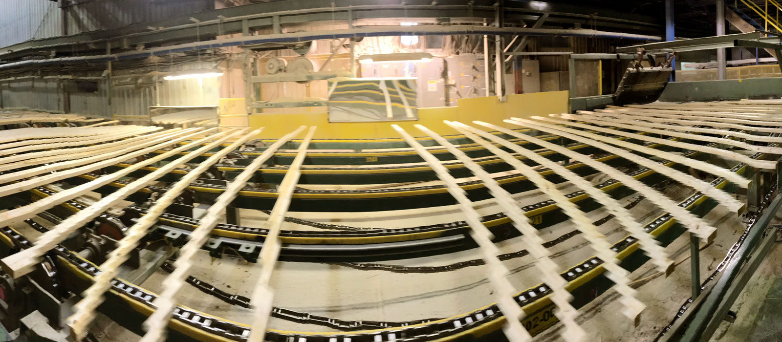Panoramic view of lumber on conveyor passing in front of mirror